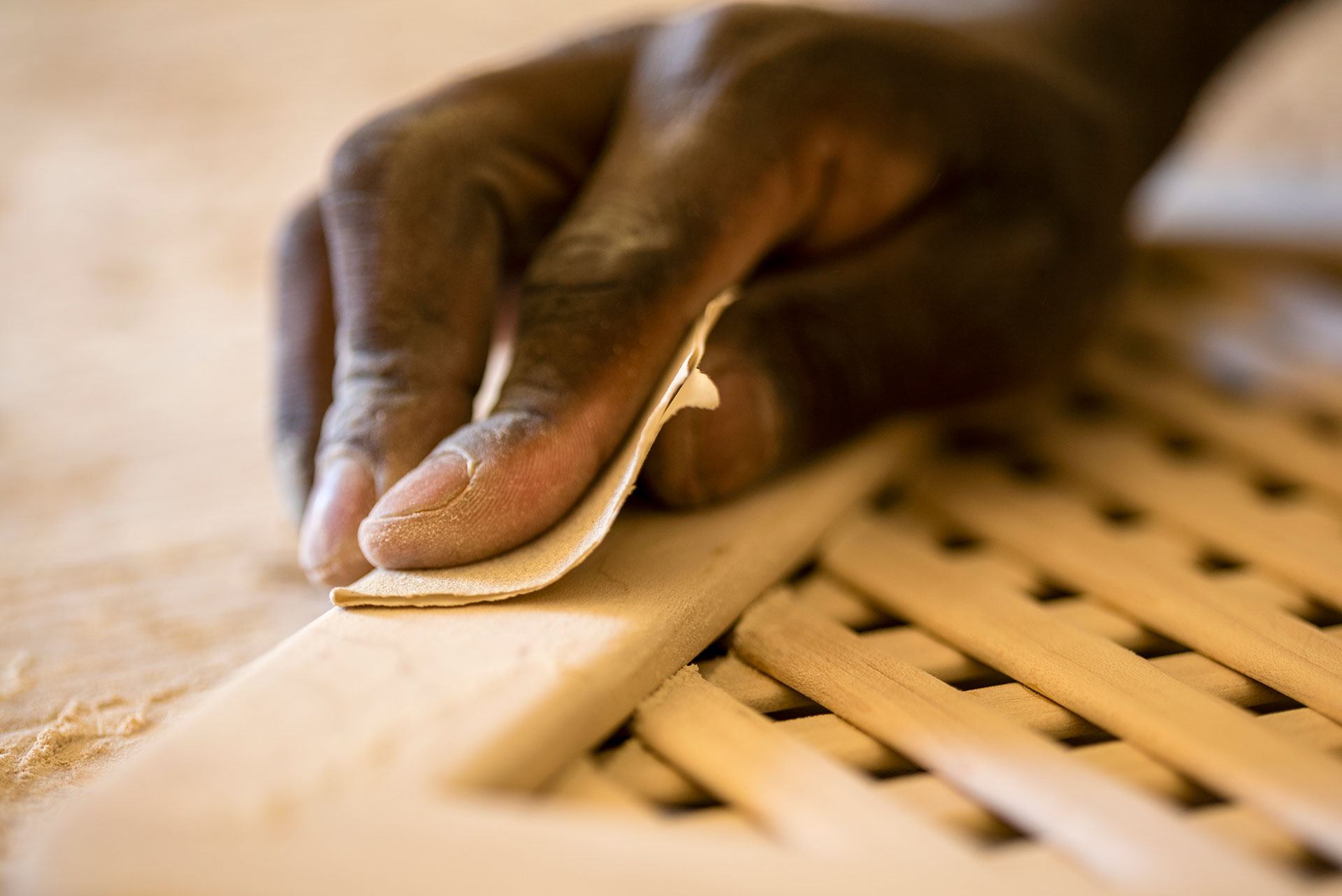 Detail of a craftsman hand-finishing timber by hand, showcasing the traditional workmanship and craft behind KYC catamarans.