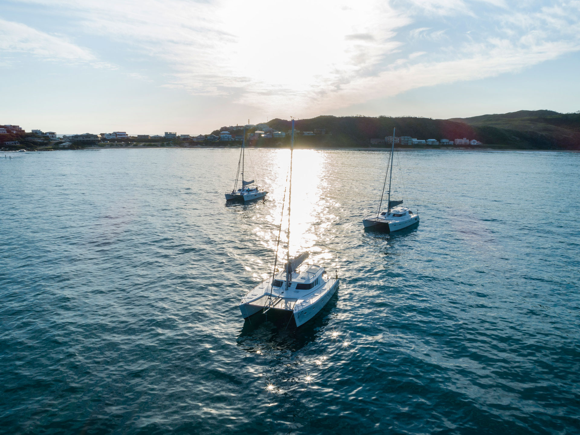 The craft behind KYC catamarans - 3 catamarans sailing on blue water